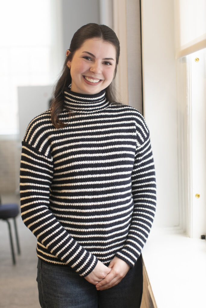 Mia McDermont stands near a window