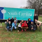 picture of students in front of NC sign.