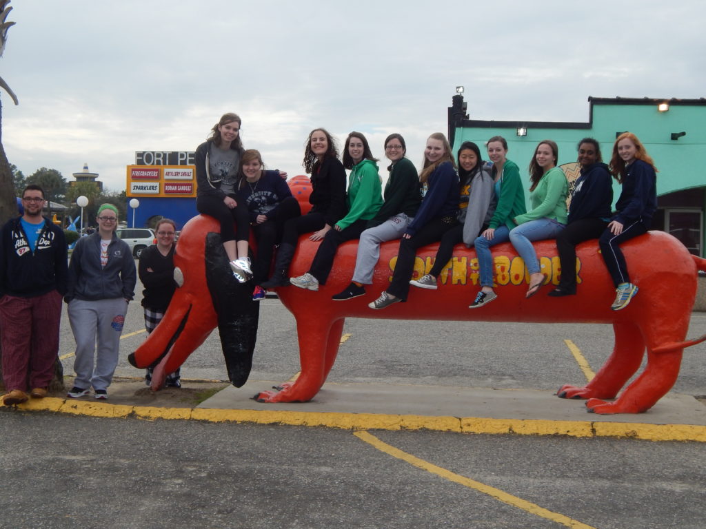 students sitting on a large sculpture of a dog