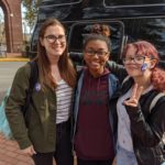 three students wearing "I voted" stickers