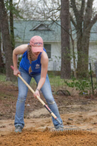 student on 2017 trip using a rake to level out the ground