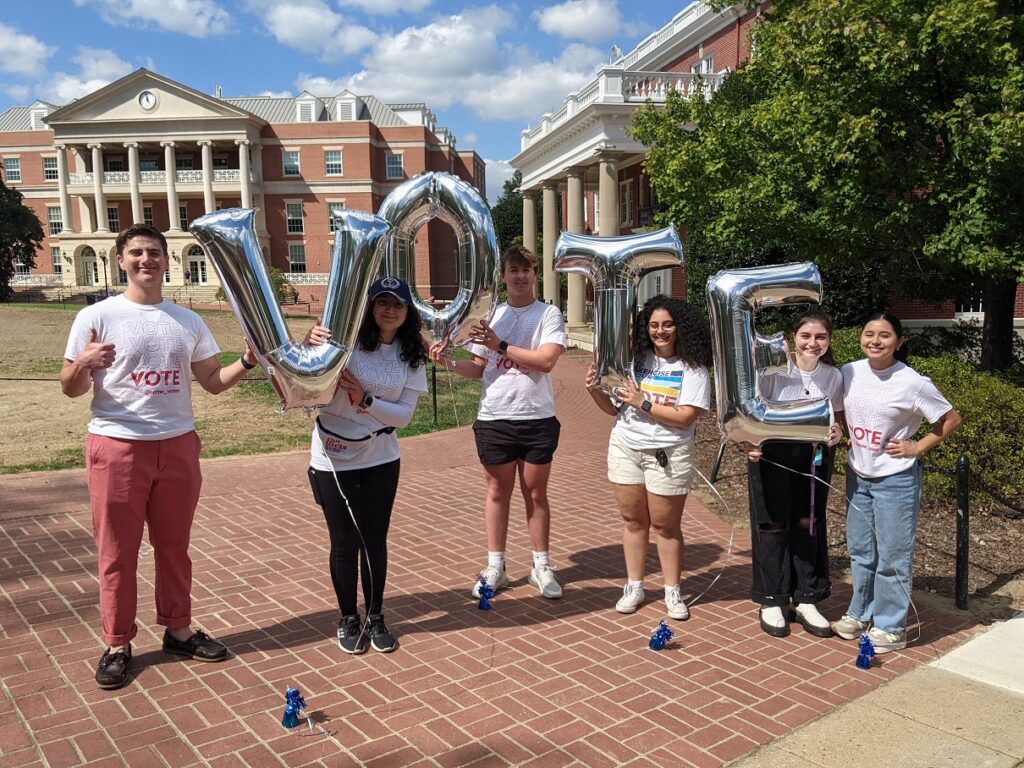 Students hold balloons that spell out "VOTE"