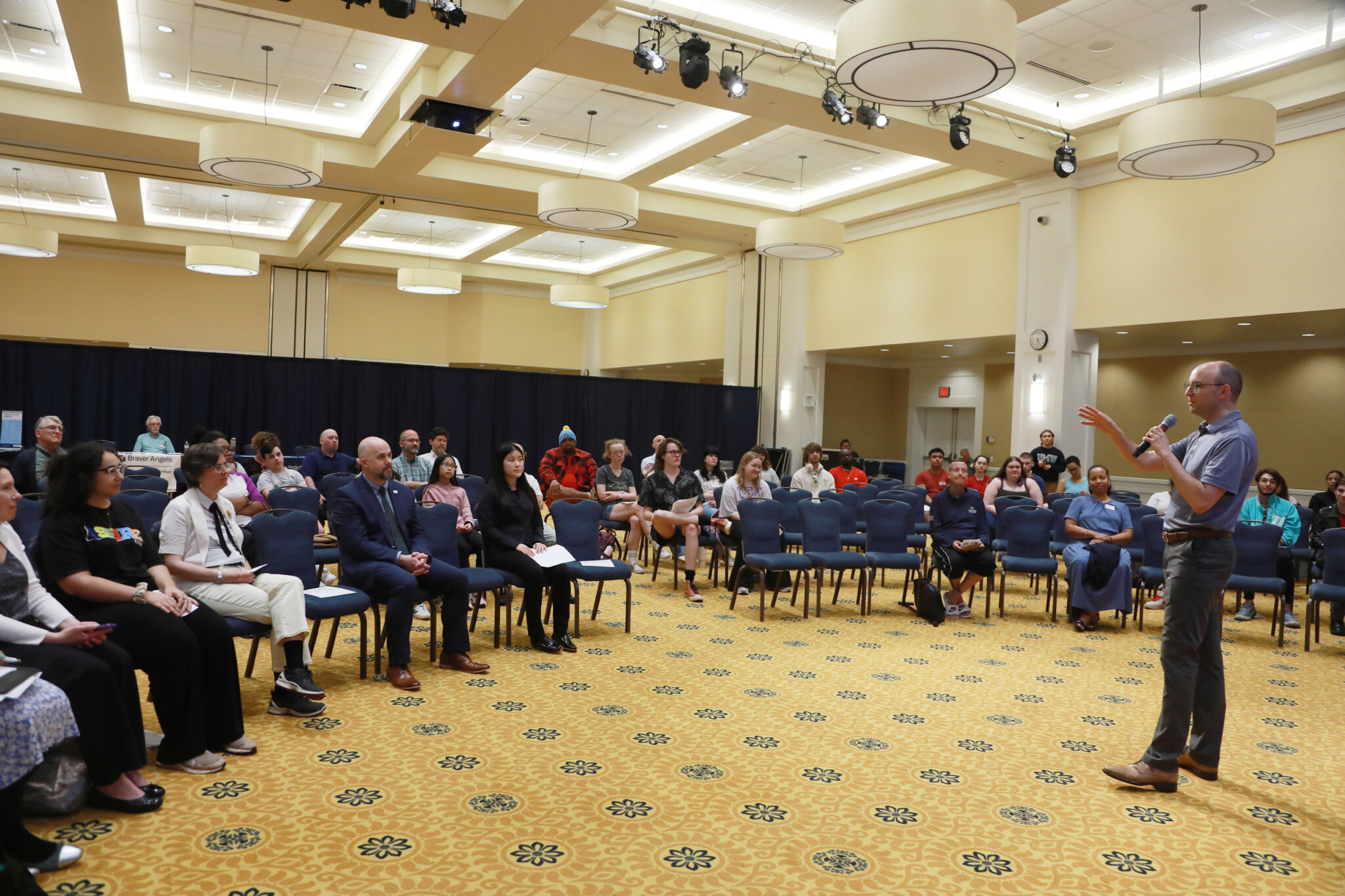 Crowd of people sitting while watching a presentation.
