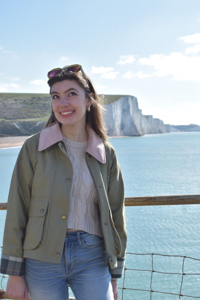 Emily, smiling in front of a white cliff.