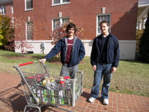 two students with a shopping cart full of cans