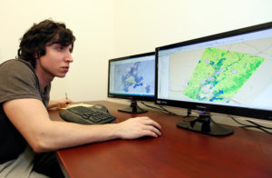 A Geography student studies a map in a Geographic Information Systems (GIS) class.