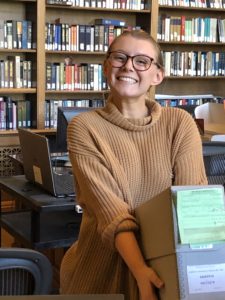 History major carrying archive boxes on UMW trip to National Archives